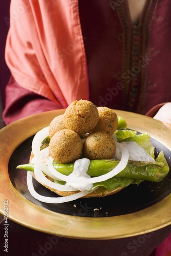 Foto: Woman serving falafel (chick-pea balls) with vegetables Woman serving falafel (chick-pea balls) with vegetables