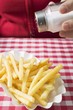 Hand sprinkling salt on chips