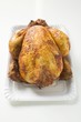 Whole roast chicken on paper plate
