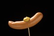 Frankfurter with mustard on cocktail stick