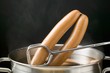 Lifting frankfurters out of hot water with tongs