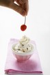 Decorating stracciatella ice cream with cherry