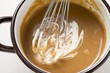 Stirring crème fraîche into gravy