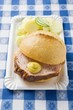 Leberkäse in roll with mustard & potato salad on paper plate