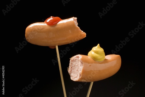 Foto: Two half frankfurters with mustard and ketchup Two half frankfurters with mustard and ketchup