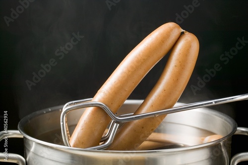 Photo: Lifting frankfurters out of hot water with tongs Lifting frankfurters out of hot water with tongs