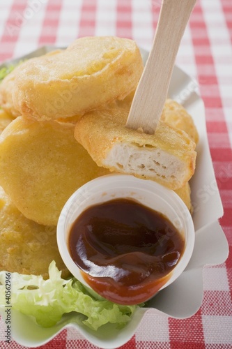 Photo: Chicken nuggets with ketchup in paper dish Chicken nuggets with ketchup in paper dish