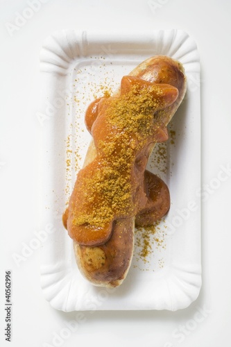 Photo: Sausage with ketchup and curry powder on paper plate Sausage with ketchup and curry powder on paper plate