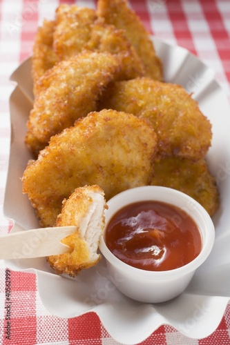 Photo: Chicken nuggets with ketchup in paper dish Chicken nuggets with ketchup in paper dish