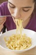 Foto: Young woman eating ribbon pasta Young woman eating ribbon pasta