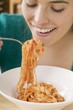 Foto: Woman eating ribbon pasta with tomato sauce Woman eating ribbon pasta with tomato sauce