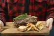 Man serving grilled T-bone steak on chopping board