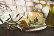 Cheese, green olives and olive oil on table out of doors