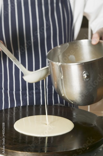 Foto: Pouring pancake mixture onto hotplate Pouring pancake mixture onto hotplate