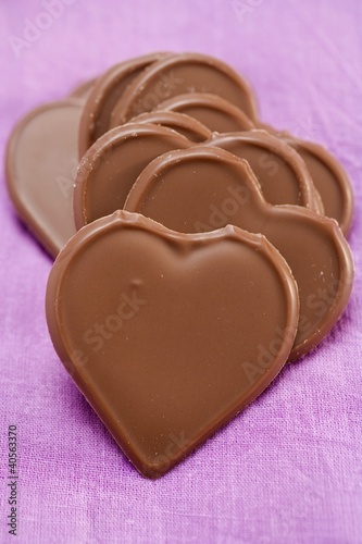 Photo: Chocolate hearts on purple background Chocolate hearts on purple background