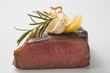 Beef steak, showing cut edge, with garlic, rosemary, lemon