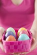 Foto: Woman holding basket of coloured Easter eggs Woman holding basket of coloured Easter eggs