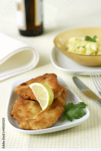 Photo: Breaded chicken escalopes, potato salad in background Breaded chicken escalopes, potato salad in background