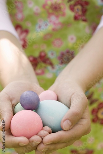 Photo: Hands holding coloured eggs Hands holding coloured eggs