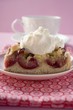 Piece of plum cake with cream in front of coffee cup
