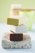 Three bars of soap on pumice stone, windlights, brush