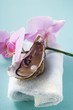 Fresh oyster with pearl on towel, orchids