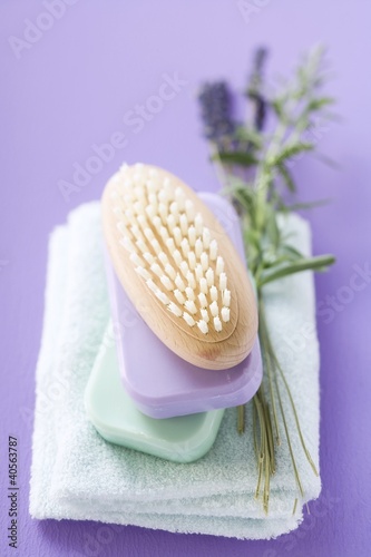 Photo: Brush and bars of soap on towel, sprig of lavender Brush and bars of soap on towel, sprig of lavender