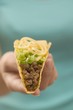 Foto: Hand holding a taco filled with mince and cheese Hand holding a taco filled with mince and cheese