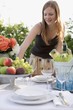 Foto: Woman by table laid in garden Woman by table laid in garden