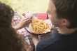 Foto: Couple eating chips in garden Couple eating chips in garden