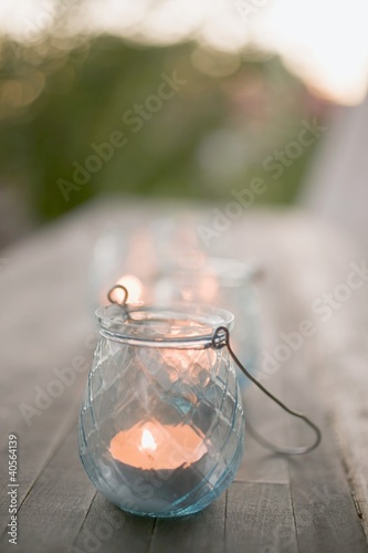 Foto: Windlight on wooden table in garden Windlight on wooden table in garden