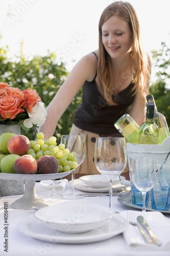 Foto: Woman by table laid in garden Woman by table laid in garden