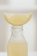 Lemon juice in bottle with fresh lemon wedge