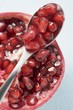 Half a pomegranate and spoonful of pomegranate seeds