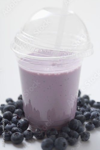 Photo: Blueberry shake in plastic cup, surrounded by blueberries Blueberry shake in plastic cup, surrounded by blueberries