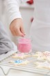 Child decorating Christmas biscuit with sugar