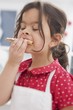 Photo: Small girl eating Christmas biscuit she has made herself Small girl eating Christmas biscuit she has made herself