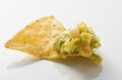Guacamole on nacho (close-up)
