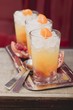 Three fruity drinks with orange and pomegranate
