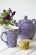 Teapot, mug of tea, fruit shortcakes and pansies