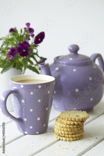 Photo: Teapot, mug of tea, fruit shortcakes and pansies Teapot, mug of tea, fruit shortcakes and pansies