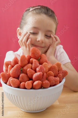 Foto: Little girl, daydreaming, with a bowl of strawberries Little girl, daydreaming, with a bowl of strawberries