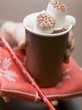 Photo: Hand holding beaker of hot chocolate with marshmallows & cream Hand holding beaker of hot chocolate with marshmallows & cream