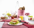 A table laid for breakfast with cheese rolls, eggs and orange juice