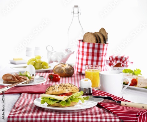 Foto: A table laid for breakfast with cheese rolls, eggs and orange juice A table laid for breakfast with cheese rolls, eggs and orange juice