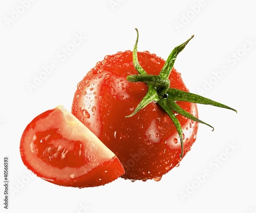 Photo: One whole and one tomato wedge with drops of water One whole and one tomato wedge with drops of water