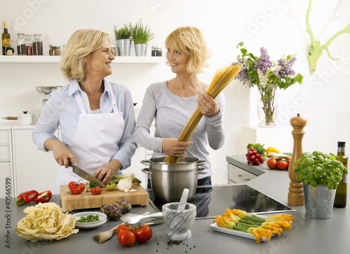 Foto: Women having a laugh while cooking spaghetti Women having a laugh while cooking spaghetti