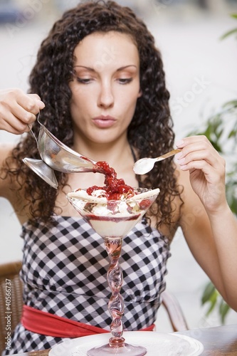 Photo: Woman pouring hot raspberries over vanilla ice cream Woman pouring hot raspberries over vanilla ice cream