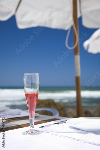 Foto: Sangria in sparkling wine glass on table on beach Sangria in sparkling wine glass on table on beach