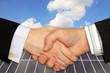 Businessmen shaking hands in front of Solar Power Station